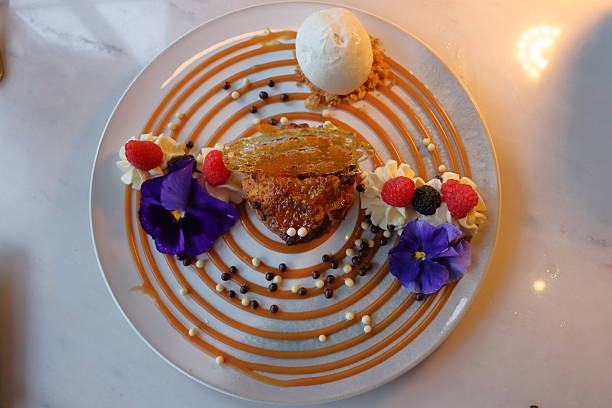 istock Cake with vanilla ice cream and flowers on a white plate. 2234478267