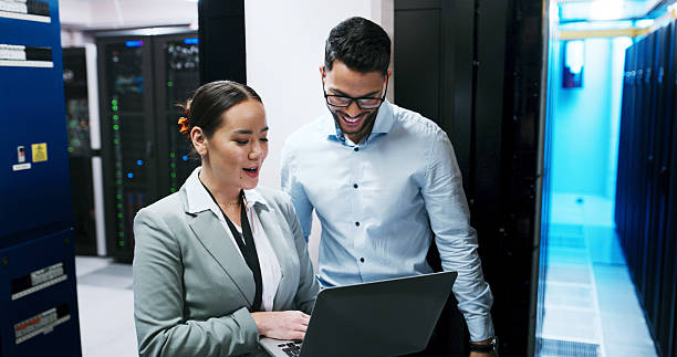 istock Server room, team and people with laptop for software, diagnostics or discussion. IT, technician and planning with computer in datacenter for cybersecurity, system maintenance or happy for solution 2234480249