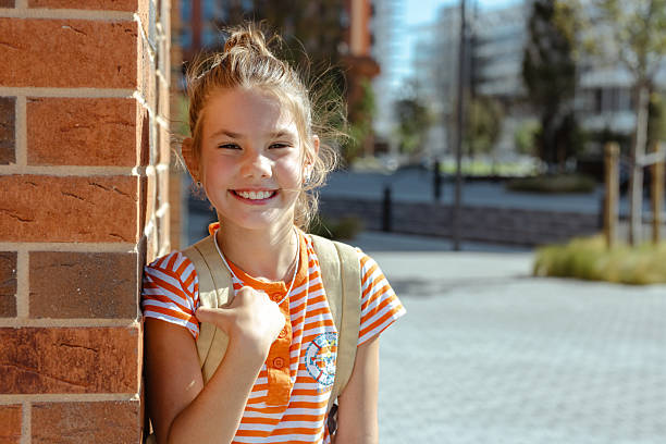 istock Smiling girl with backpack standing in an urban outdoors environment 2234481651