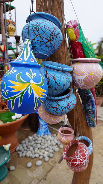 istock Blue, pink, and red painted pots hang on tree 2234481972