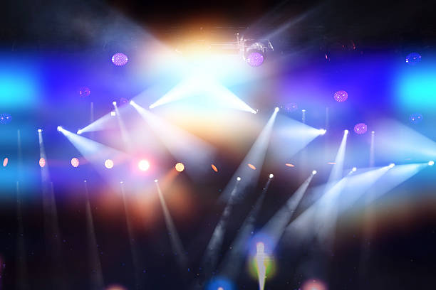 istock A stage with multiple spotlights and colorful lights illuminating the area. 2234482303