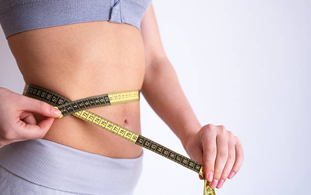 istock Hands measuring waist with tape measure 2234484368
