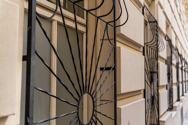detail of barred windows at ground floor of old building in city of vienna, shallow focus on black grills in front