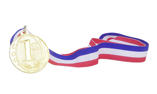 Three gold medals on wooden table.