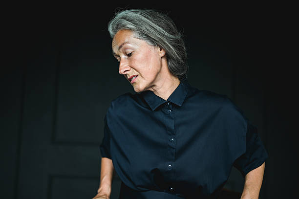 istock Elegant mature woman looking down in thoughtful pose 2234492117
