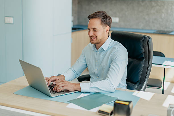 istock Professional businessman working on laptop in modern office environment with cheerful demeanor 2234493656