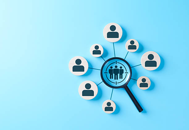 istock Magnifying glass focusing on target customer group with human icons on blue background, representing business marketing, audience analysis, customer segmentation, recruitment, human resource strategy, 2234493898