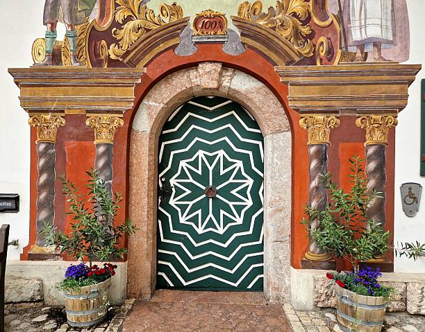 landscaped gardened church yard entrance space of stairs path flower pots and huge wooden door with lanterns and white high walls exterior facade religion building aged architecture landmark