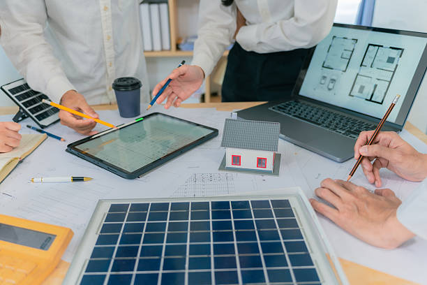 istock Architecture and Construction Concepts - Group of architects with laptop computers meeting with plans on rooftop to plan building design. 2234494353