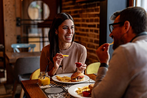 istock Cheerful young couple having lunch together at a restaurant 2234494601