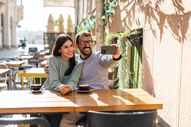 istock Happy couple taking a selfie while enjoying coffee at outdoor cafe 2234495108