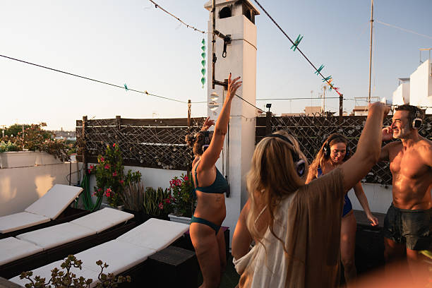 istock Friends enjoying silent disco on rooftop at sunset 2234495409