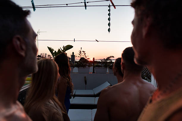Group of friends enjoying a breathtaking sunset view from a rooftop
