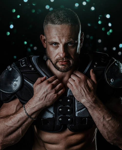 istock American football athlete in protective equipment, dramatic light studio shot dark background 2234496520