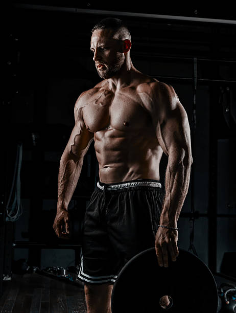 istock Muscular man having training with weights. Strong athletic man does workout. Concept bodybuilder doing exercises in gym. 2234496523
