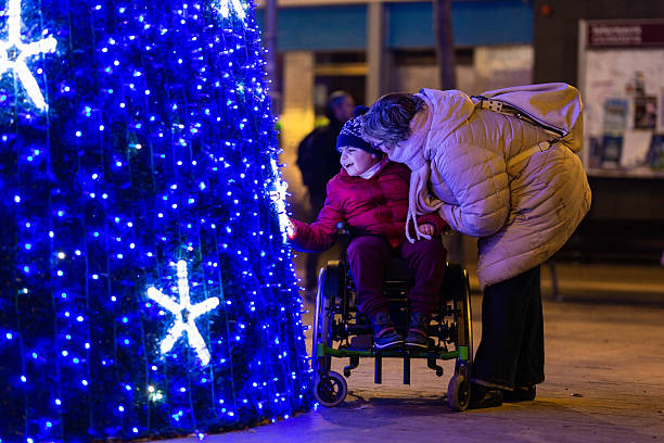 Disabled child enjoying christmas tree with mother