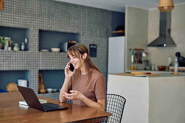 istock Freelancer talking on phone and using laptop at home 2234502317