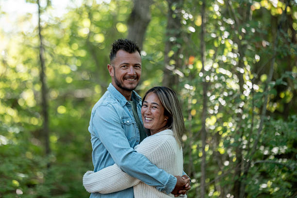istock Cheerful Couple Embracing in a Green Forest Setting 2234503017