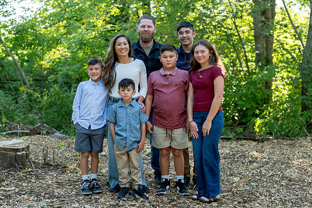 istock Happy Diverse Family Posing Outdoors in Bright Sunlit Forest Setting 2234503021
