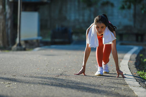 Woman athlete in starting position for running outdoors