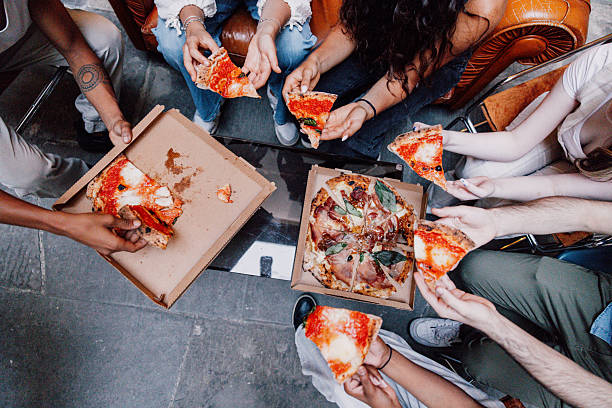 One friend reaches for a slice while others are mid-conversation, creating a natural moment of shared fun. It’s the kind of memory that feels effortless but lingers for years.