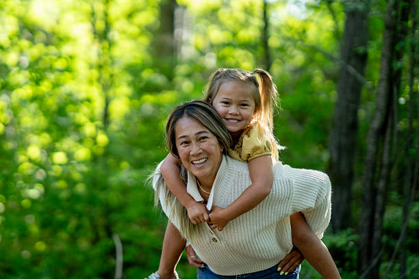 istock Mother and Daughter Smiling Together Outdoors in a Forest Setting 2234506247