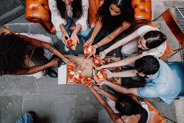 Shared moments of joy while grabbing pizza slices during an evening hangout