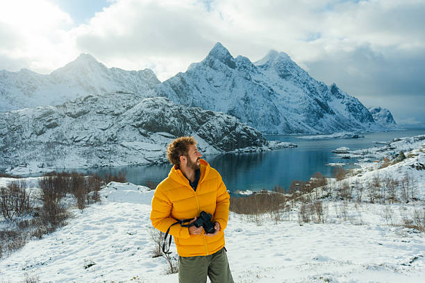 Man exploring seaside on Lofoten islands  during trip to Norway in  winter