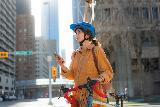 istock Woman using smartphone cycling through the downtown in springtime 2234510215