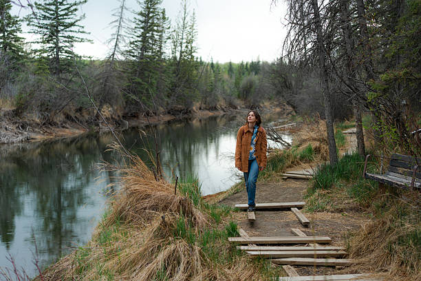 Serene woman  walking along the river on the education path