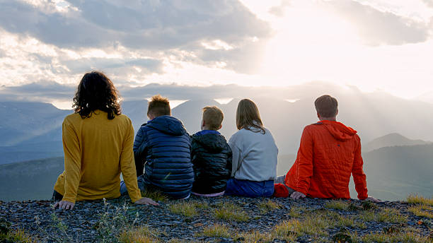 istock Family explores mountain ridge crest at sunset 2234511040