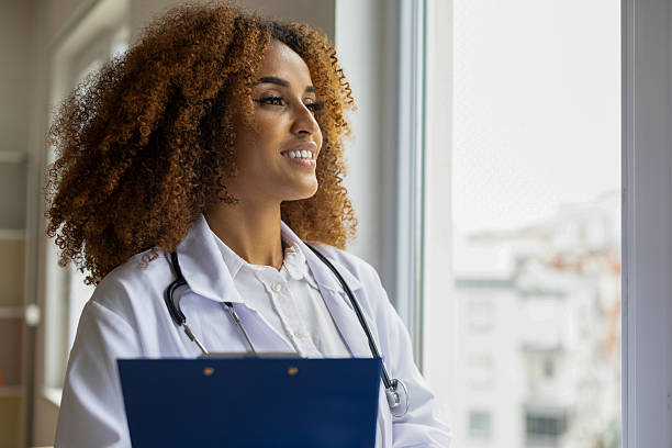 istock Smiling female doctor looking through window 2234512927