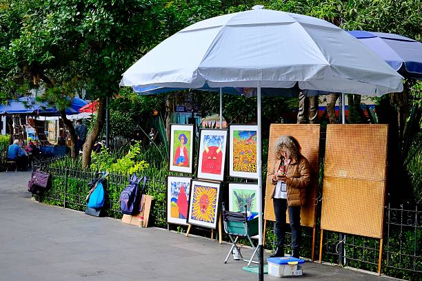 Mexico City, DF, Mexico – September 6, 2025: An artist stands next to her work, on display for sale in the CDMX neighborhood of Coyoacan.