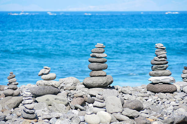 istock Stone Cairns on Rocky Beach with Blue Sea in Background 2234514033