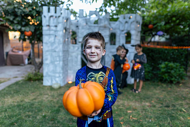istock Smiling boy in a pirate skeleton costume holding a pumpkin during Halloween. 2234514044