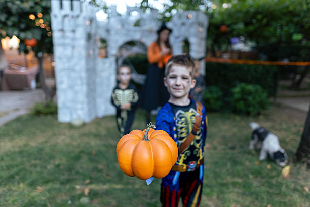 istock Smiling boy in a pirate skeleton costume holding a pumpkin during Halloween. 2234514046