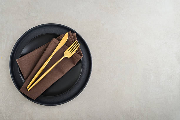 istock table place setting with black plates and golden cutlery 2234515587