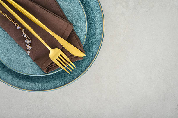 istock table place setting with blue plates and golden cutlery 2234515594