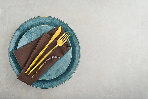 istock table place setting with blue plates and golden cutlery 2234515596