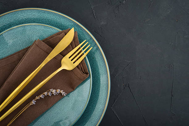 istock table place setting with blue plates and golden cutlery on black  background 2234515602