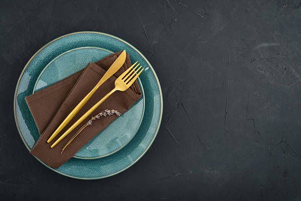 istock table place setting with blue plates and golden cutlery on black  background 2234515604