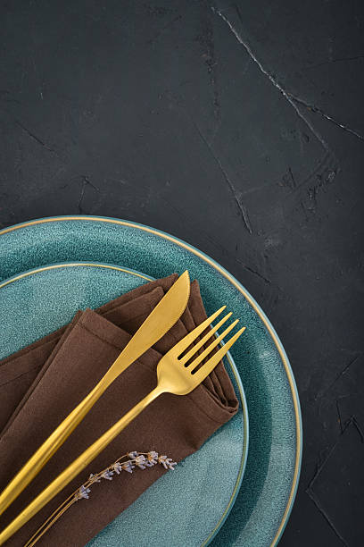 istock table place setting with blue plates and golden cutlery on black  background 2234515605