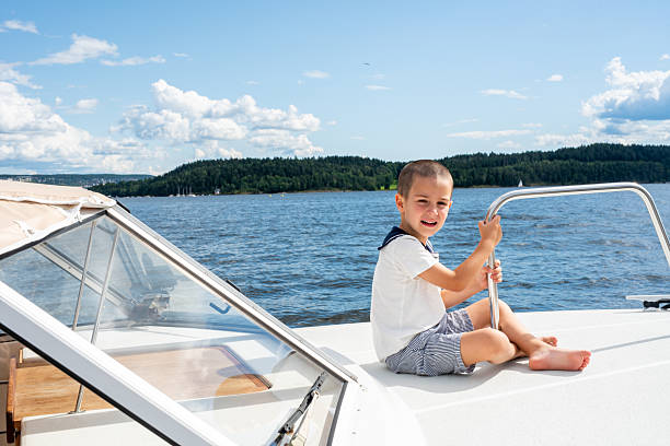 Children, playing on a boat in a river, summertime, watching nature with binoculars, sunny weather summertime