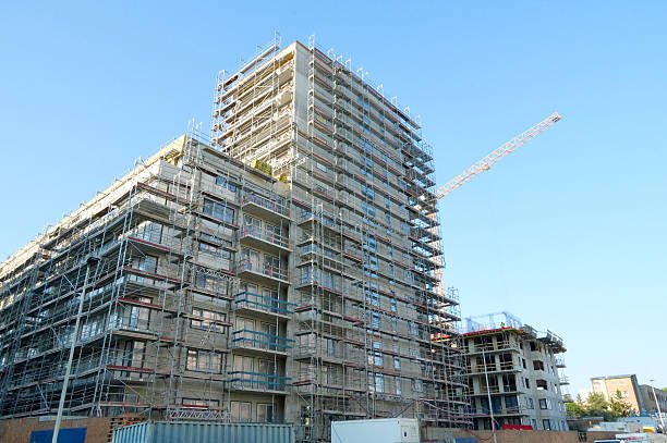istock Multi-storey building under construction with scaffolding against blue sky 2234519894