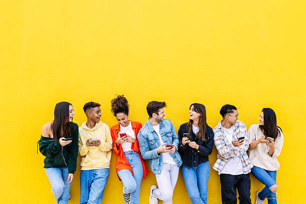 istock Multiracial young friends having fun sharing media content on mobile phone 2234522898