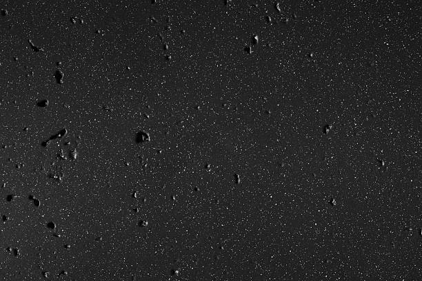Black industrial metal wall surface with scattered white dot spatter