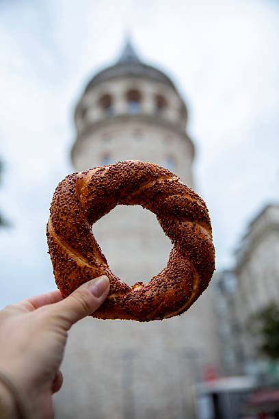 istock Female hand with Turkish bagel against Galata tower 2234524520