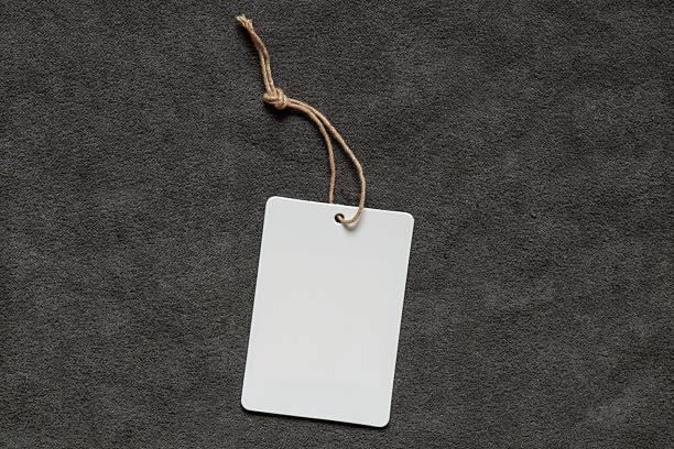 istock White empty tag on rope lies on gray fleecy fabric as a mockup for design 2234527631