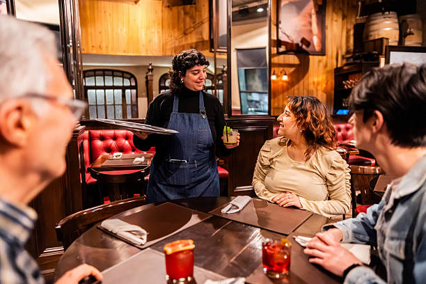 istock Waitress serving drinks to customers in a bar 2234541179