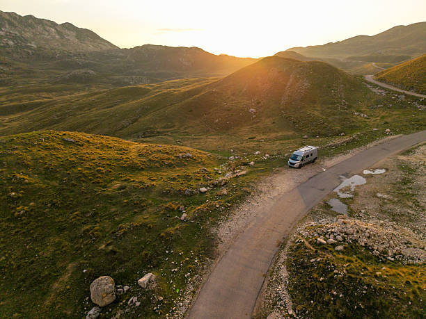 istock Camper Van Traveling Through Mountain Road Sunset 2234542238